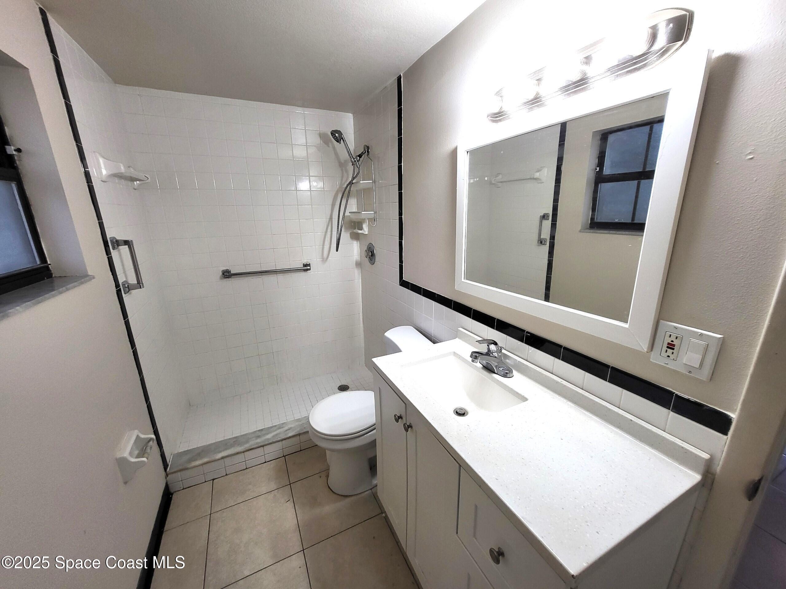 2351 Shenandoah Road Palm Bay, FL 32905 - Photo 13 of 28 a bathroom with a sink mirror vanity and toilet