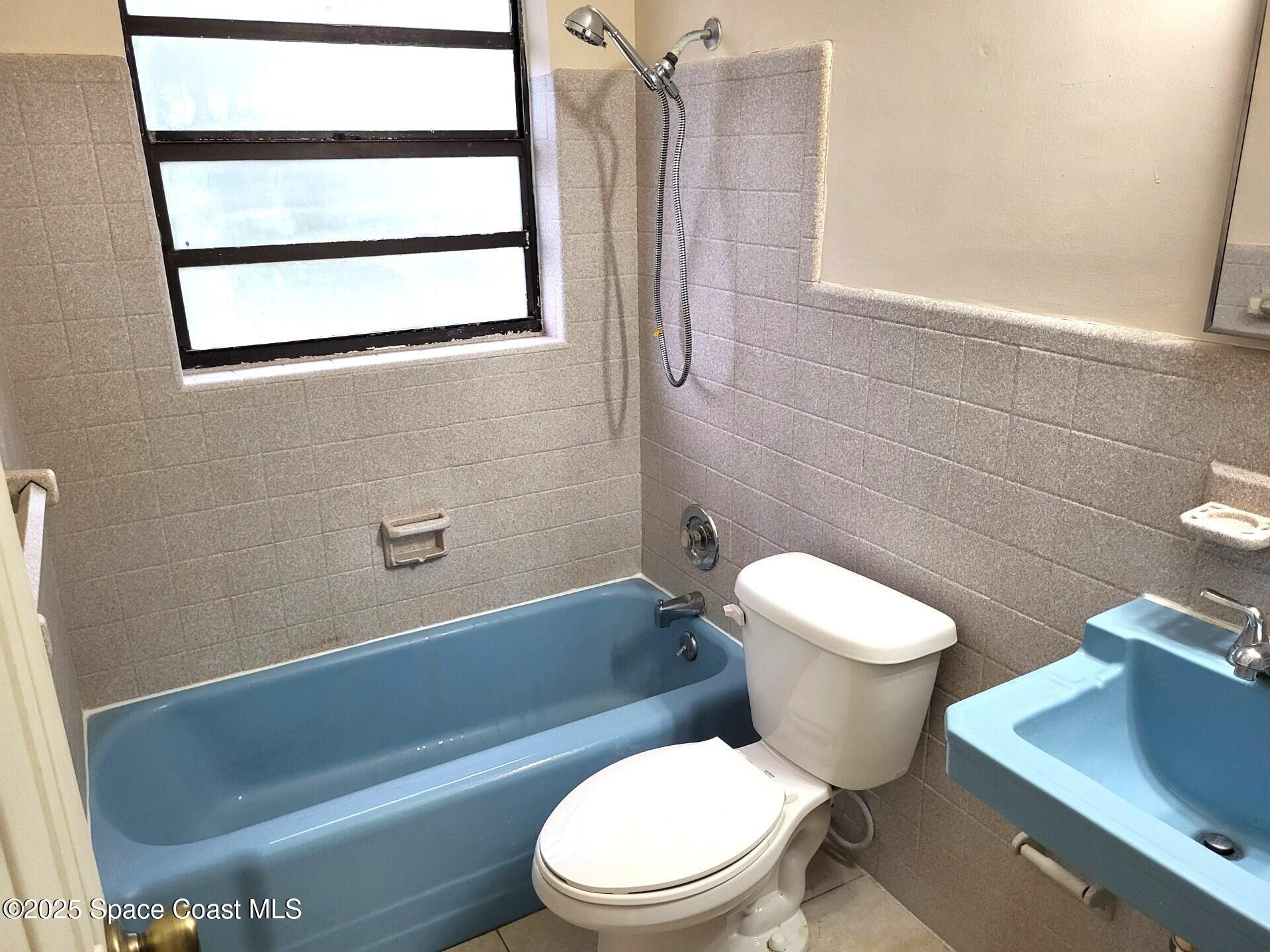2351 Shenandoah Road Palm Bay, FL 32905 - Photo 16 of 28 a white toilet sitting next to a bath tub