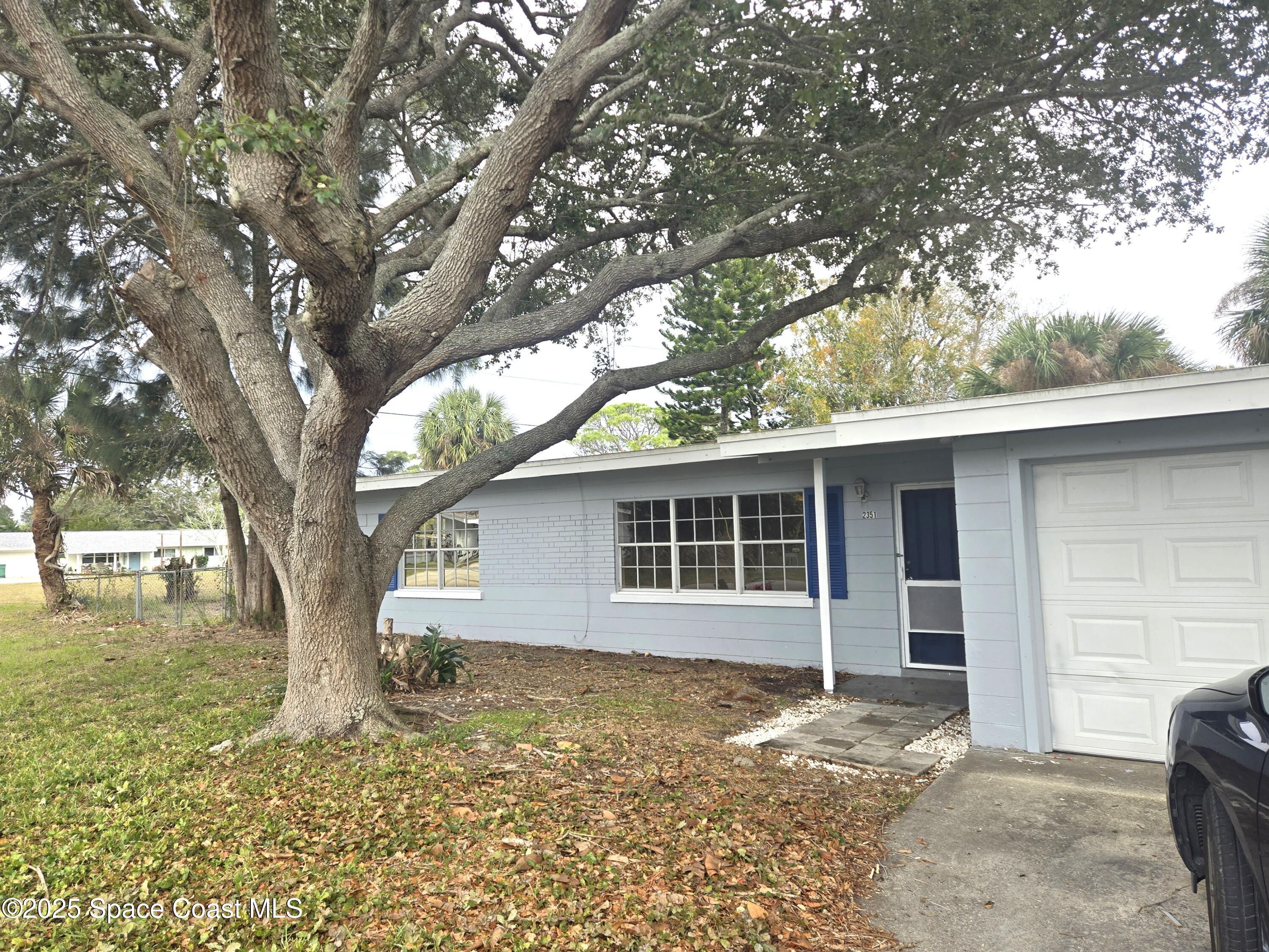 2351 Shenandoah Road Palm Bay, FL 32905 - Photo 2 of 28 a house with trees in the background