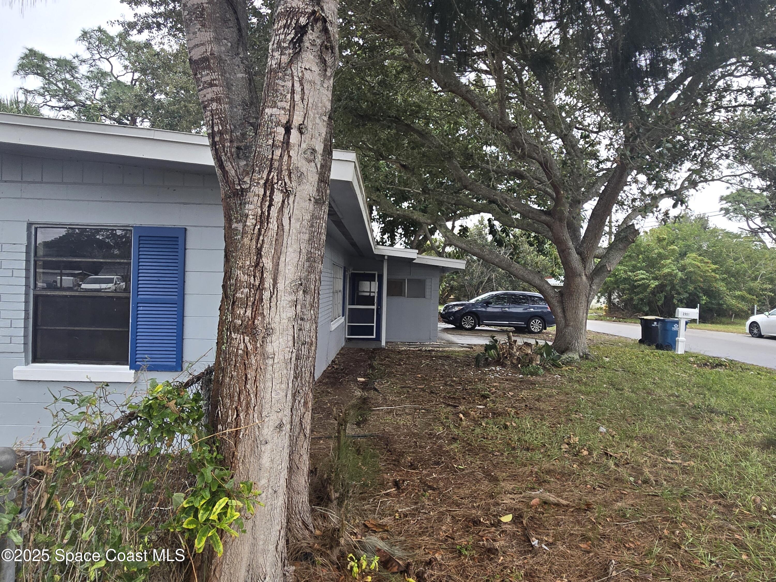 2351 Shenandoah Road Palm Bay, FL 32905 - Photo 26 of 28 a house with trees in front of it