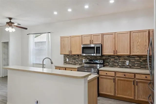a kitchen with stainless steel appliances a sink stove and cabinets