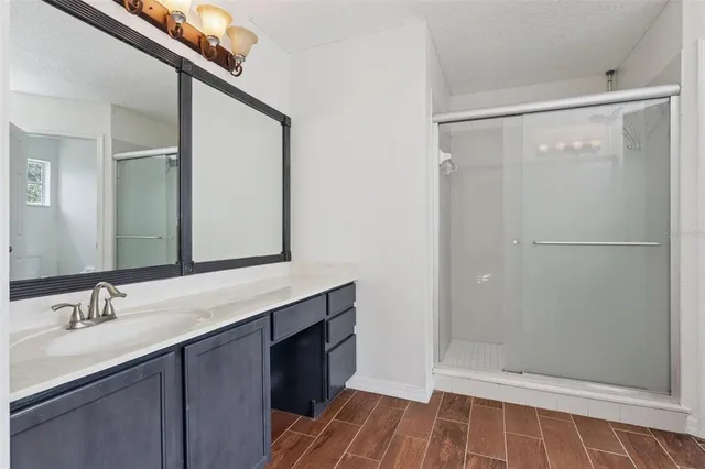 a bathroom with a shower sink and mirror