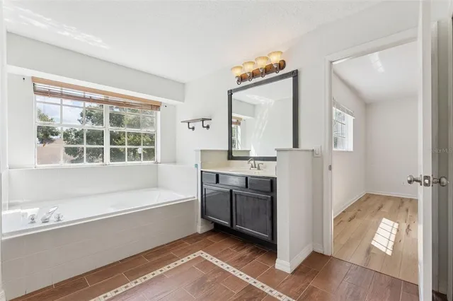 a bathroom with a bathtub sink and mirror