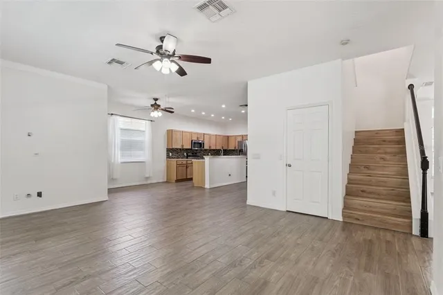 a view of a kitchen with wooden floor and a ceiling fan
