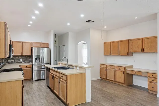 a kitchen with stainless steel appliances granite countertop a sink stove and refrigerator