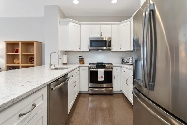 a kitchen with stainless steel appliances white cabinets and a sink