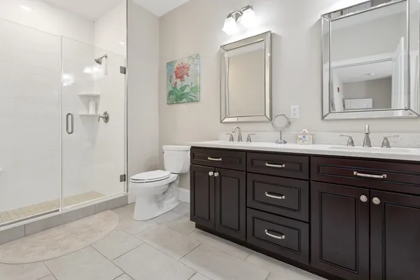 a bathroom with a granite countertop toilet sink and mirror
