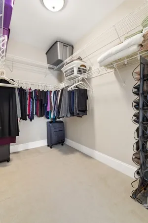 a view of walk in closet with clothes and shoes