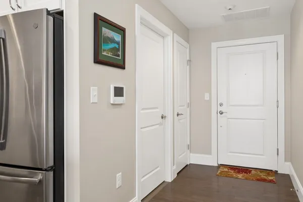a view of a hallway with wooden floor and cabinets