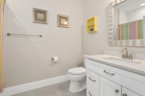 a bathroom with a granite countertop sink toilet and a mirror