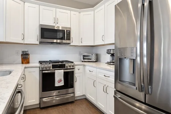 a kitchen with stainless steel appliances granite countertop white cabinets and a granite counter tops