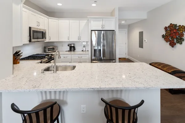 a kitchen with a table chairs refrigerator and microwave