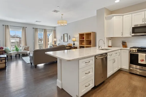 a kitchen with a sink stove and wooden floor