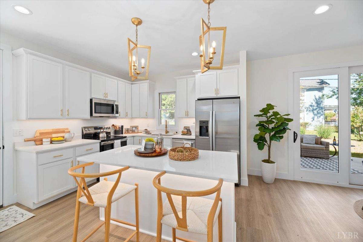 1101 Harrison Street Lynchburg, VA 24504 - Photo 20 of 66 a kitchen with stainless steel appliances granite countertop a refrigerator a stove a microwave oven a sink with wooden floor and cabinets
