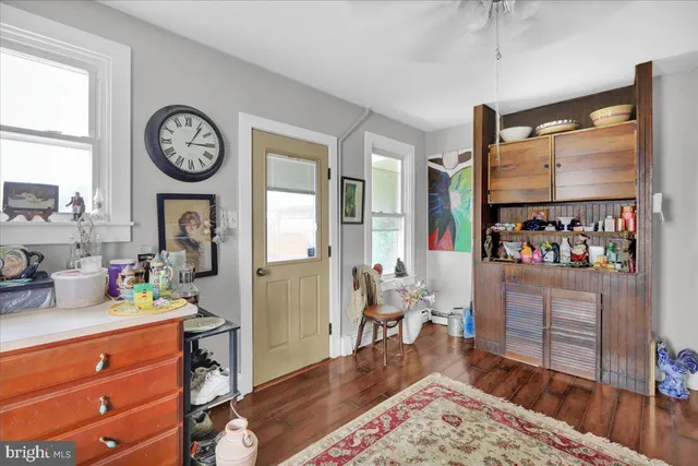 a living room with furniture a large window and wooden floor
