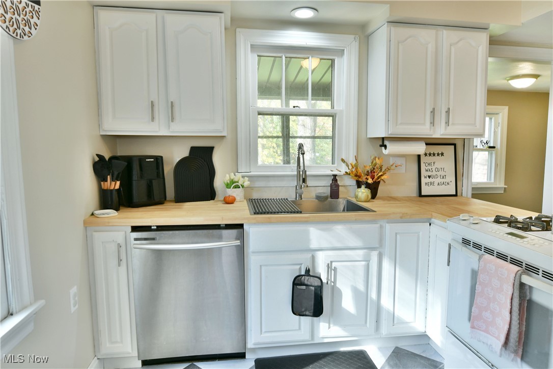572 Howland Wilson Road Southeast Warren, OH 44484 - Photo 11 of 50 Kitchen featuring sink, dishwasher, white cabinets, and white gas stove