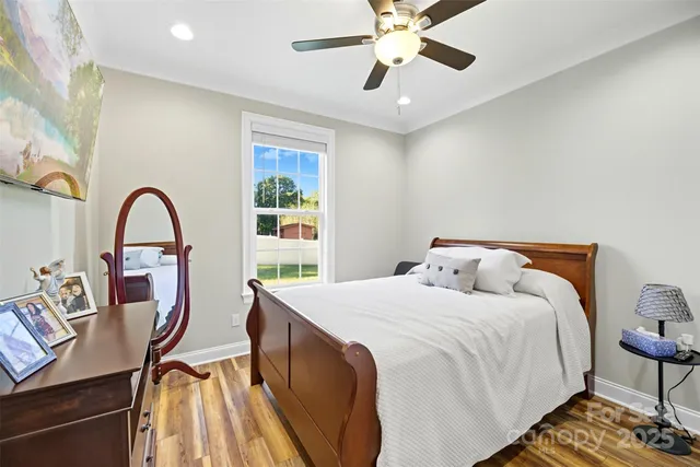 a bedroom with a bed and a dining table with wooden floor