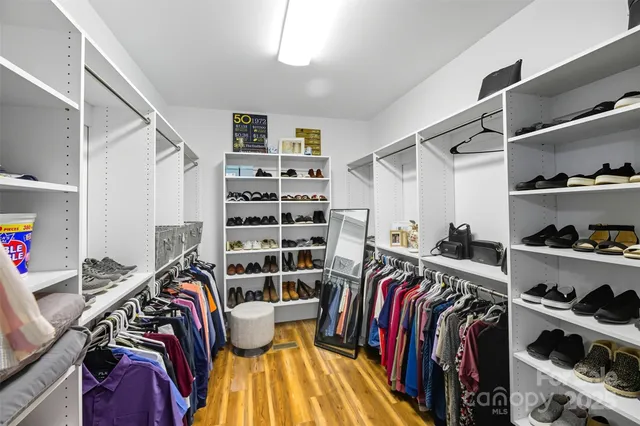 a view of walk in closet with clothes and shoes