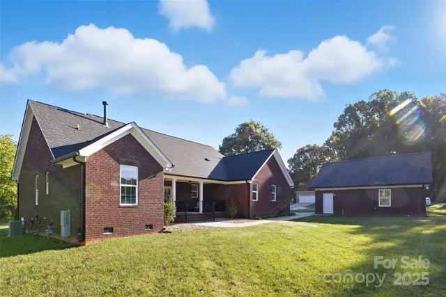 a front view of house with yard and trees in the background