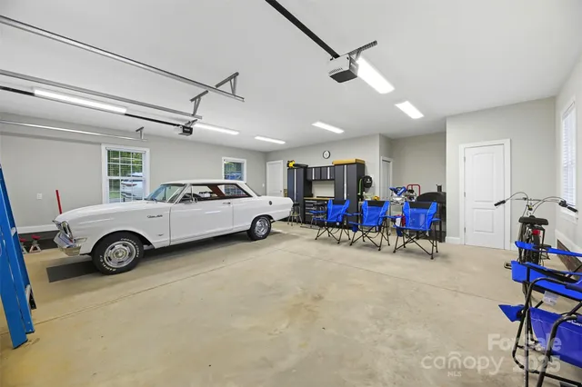a view of a garage with furniture and a car parked