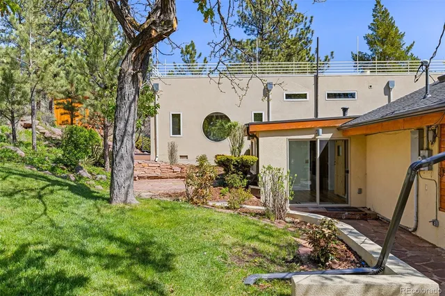 a view of a wooden house with a bench and plants