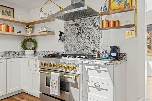 a kitchen with stainless steel appliances granite countertop a stove and cabinets