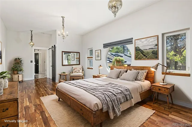 a bedroom with a large bed and a chandelier