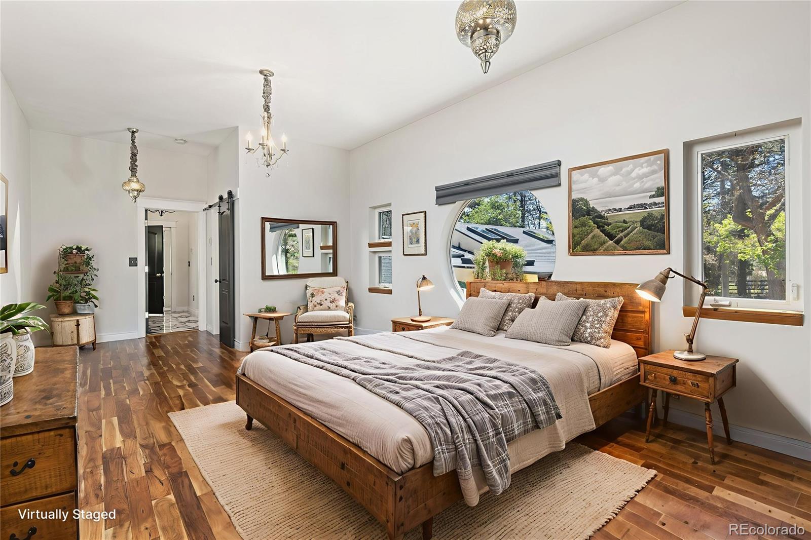 1669 Apple Valley Road Lyons, CO 80540 - Photo 37 of 48 a bedroom with a large bed and a chandelier