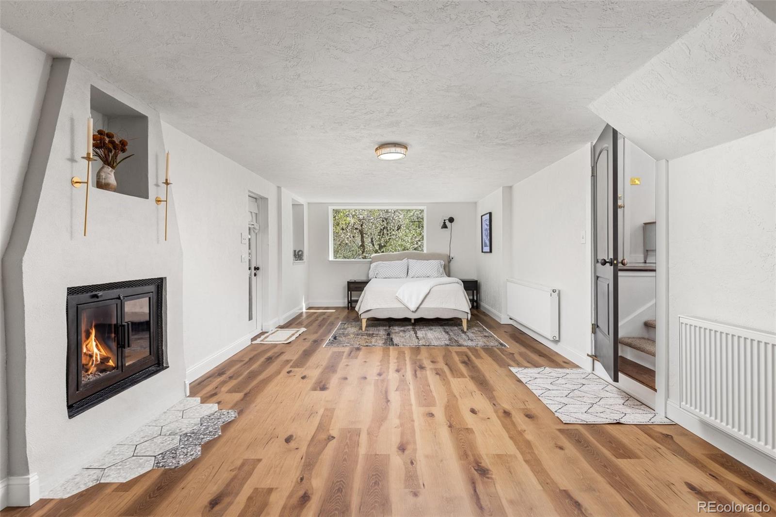 1669 Apple Valley Road Lyons, CO 80540 - Photo 44 of 48 a bedroom with a bed and a fireplace