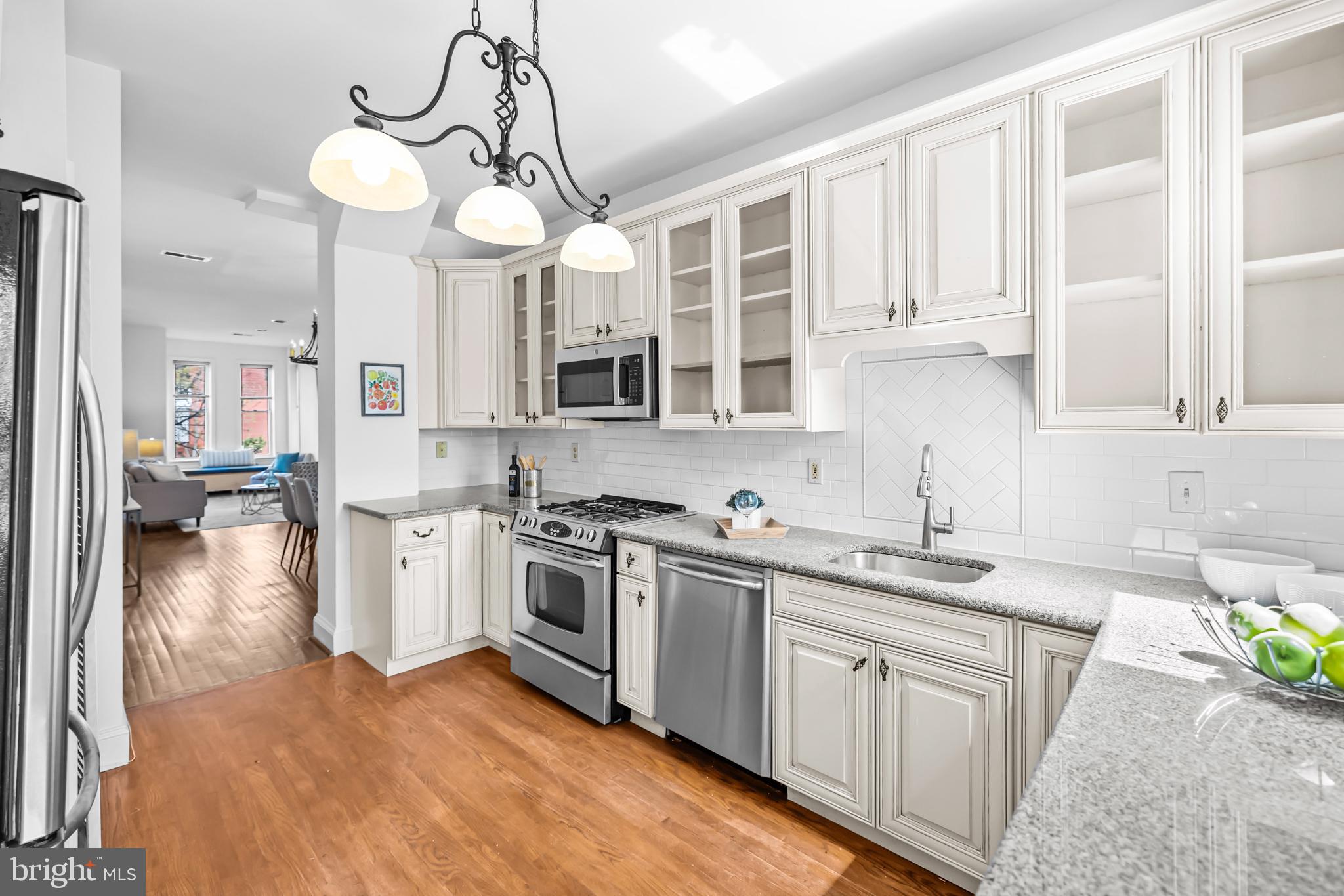 661 F Street Northeast Washington, DC 20002 - Photo 15 of 64 a kitchen with stainless steel appliances granite countertop a sink a stove oven a refrigerator with white cabinets and wooden floor