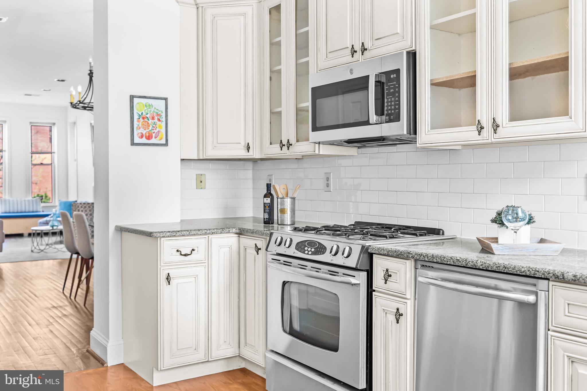 661 F Street Northeast Washington, DC 20002 - Photo 45 of 64 a kitchen with stainless steel appliances granite countertop a stove and a microwave