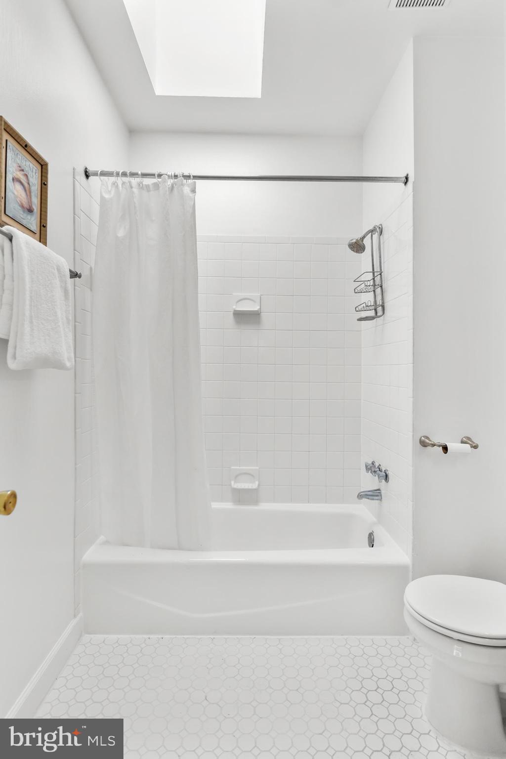 661 F Street Northeast Washington, DC 20002 - Photo 50 of 64 a bathroom with a shower curtain and a bath tub