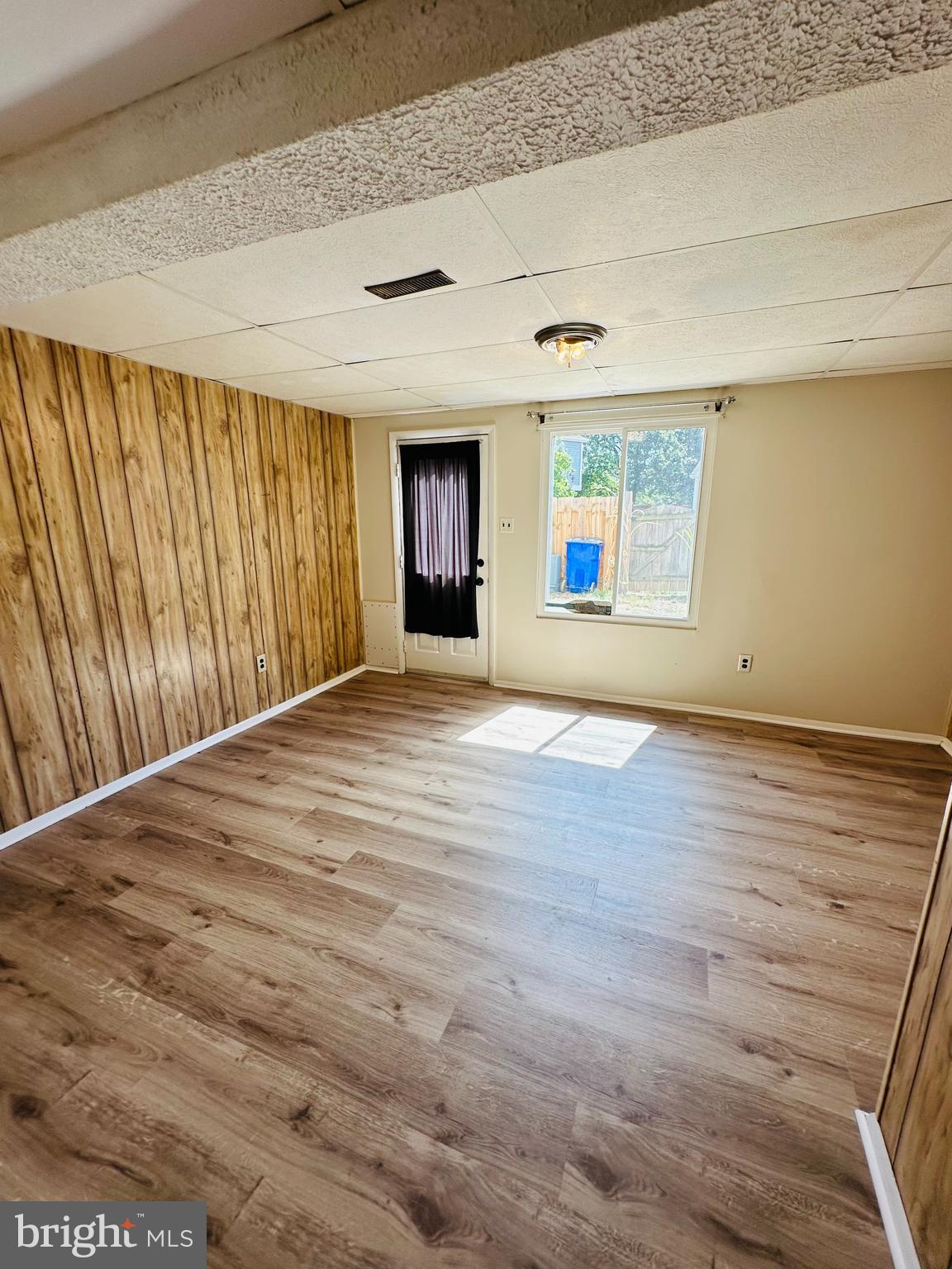 6820 Farmbrook Court Frederick, MD 21703 - Photo 14 of 17 en empty room with wooden floor and windows