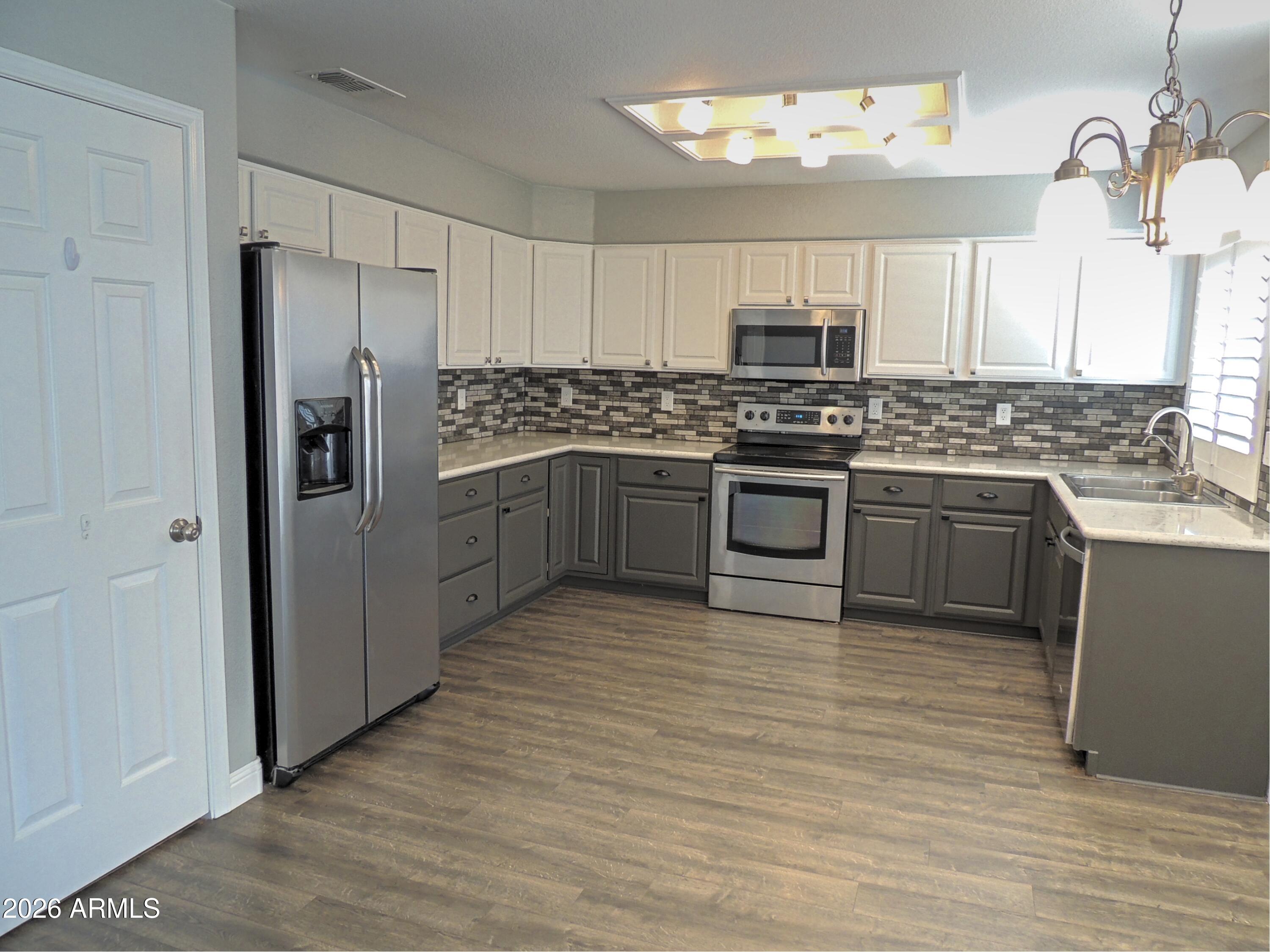 4409 East Dry Creek Road Phoenix, AZ 85044 - Photo 6 of 34 a kitchen with stainless steel appliances granite countertop a stove and a refrigerator