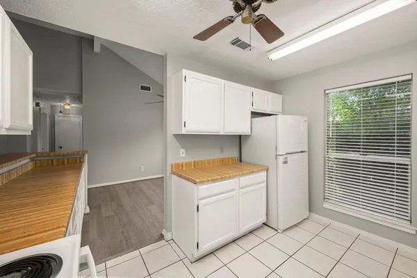 a kitchen with a stove a refrigerator and cabinets