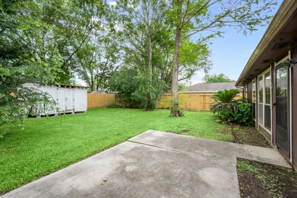 a view of a backyard with potted plants and large trees