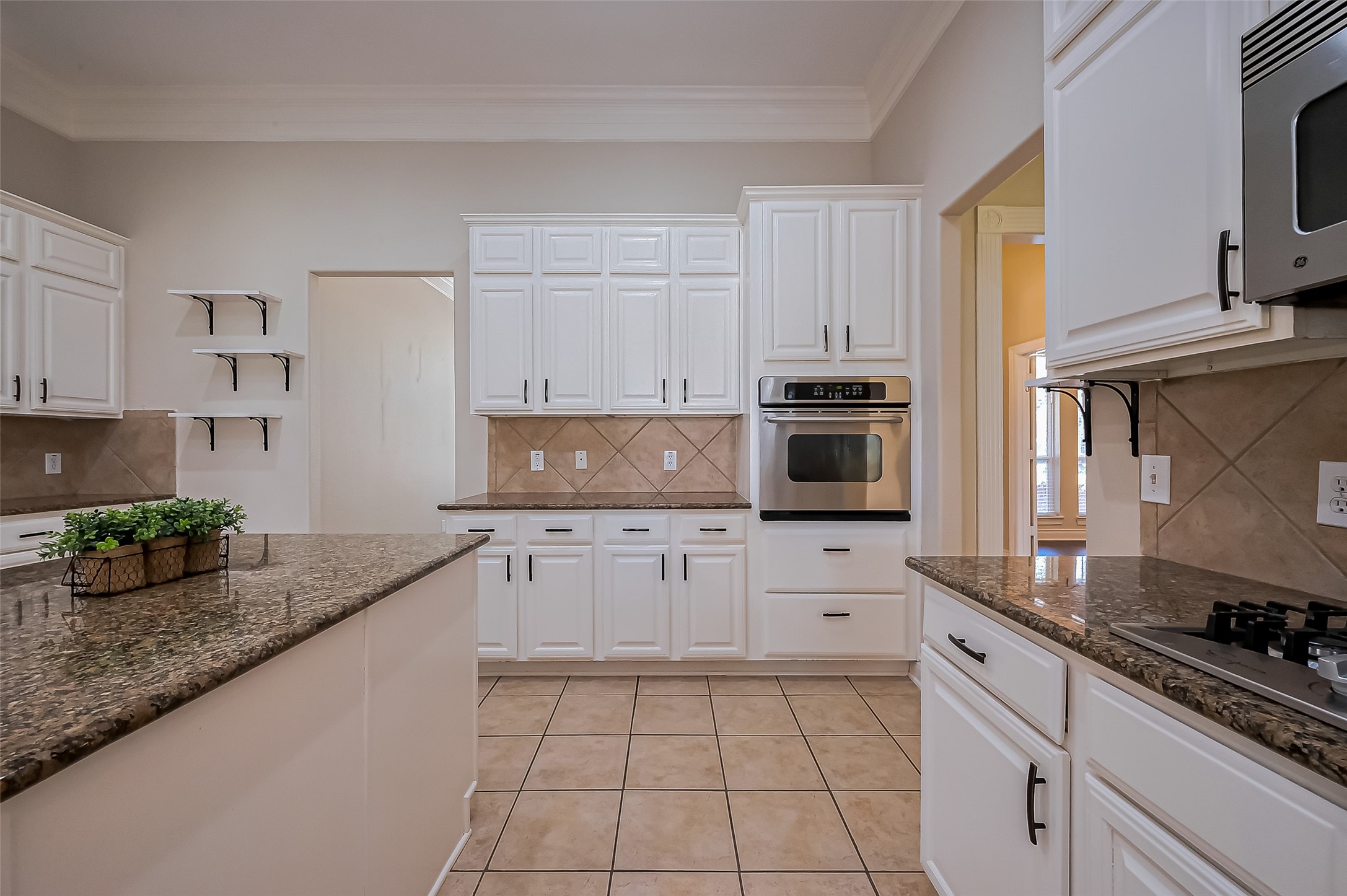 19010 Grove Valley Trail Houston, TX 77084 - Photo 20 of 50 a kitchen with stainless steel appliances granite countertop a stove a sink and white cabinets