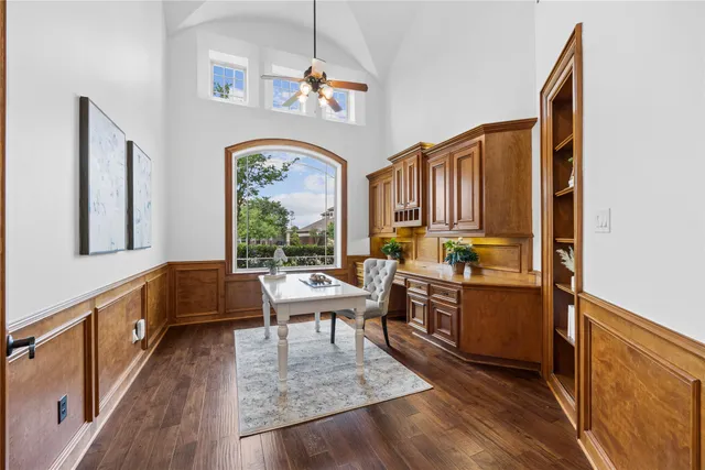 a room with kitchen island granite countertop wooden floors and a sink