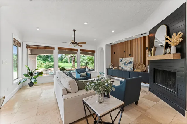 a living room with furniture a fireplace and a large window