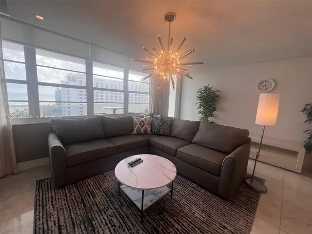 a living room with furniture a lamp and a table