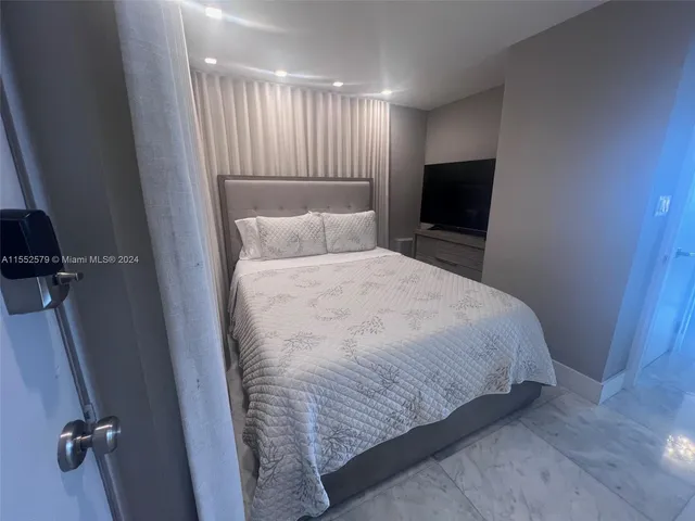 a large bed in a bedroom next to a window