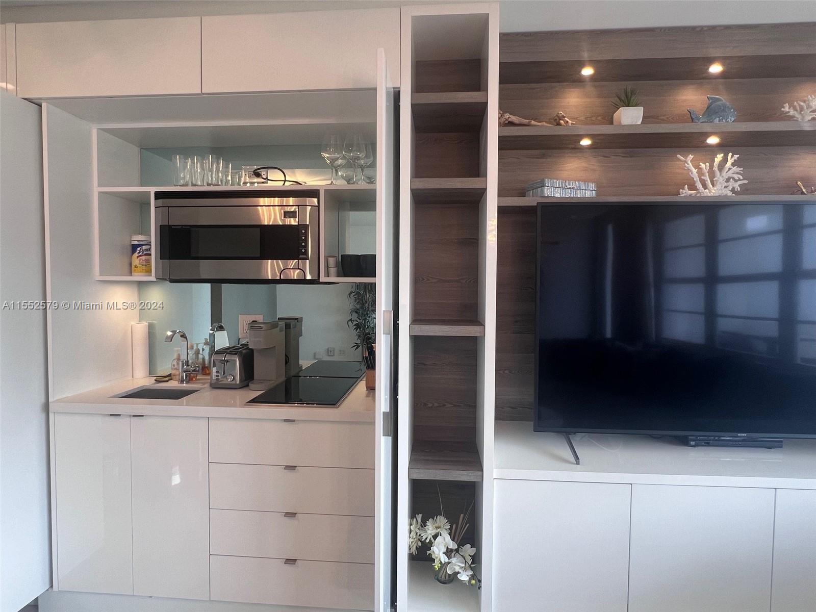 100 Lincoln Road, Unit 1536 Miami Beach, FL 33139 - Photo 9 of 18 a kitchen with a refrigerator and a microwave