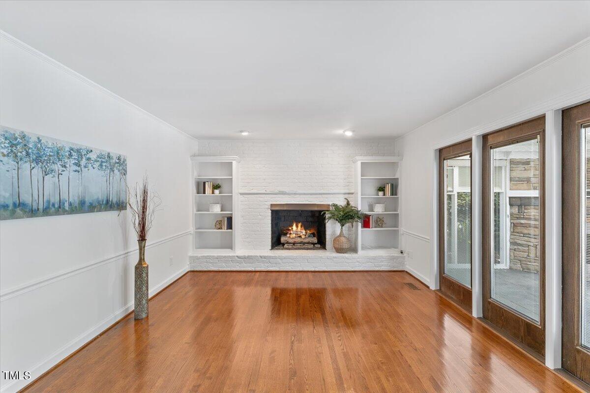 1005 Pebblebrook Drive Raleigh, NC 27609 - Photo 14 of 37 a view of an empty room with wooden floor and a window