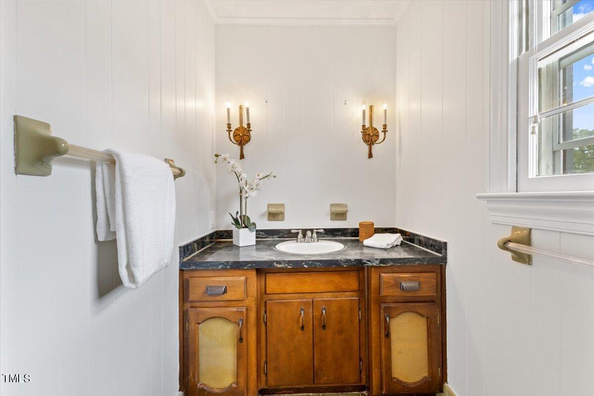 1005 Pebblebrook Drive Raleigh, NC 27609 - Photo 17 of 37 a bathroom with a granite countertop sink a mirror and shower view