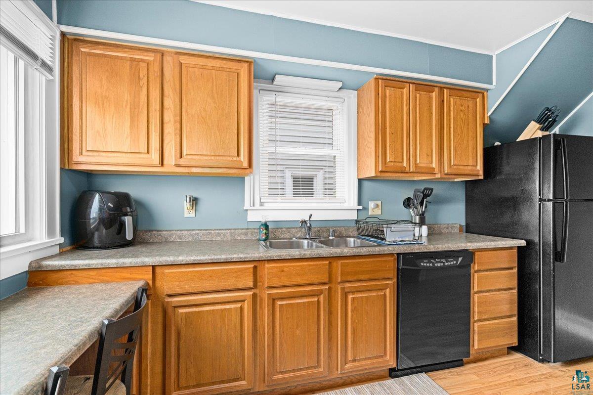 4316 West 6th Street Duluth, MN 55807 - Photo 24 of 38 Kitchen featuring black appliances, light wood finished floors, healthy amount of natural light, and wood finish cabinetry