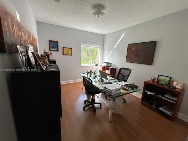 a view of a workspace with furniture and a window