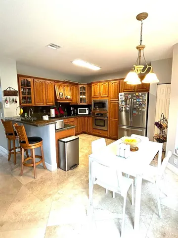a kitchen with a stove a counter top space and dining table