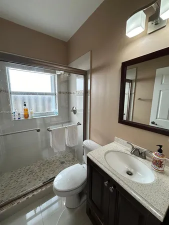 a bathroom with a granite countertop sink toilet and a mirror