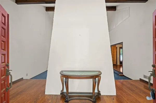a view of a room with wooden floor and mirror