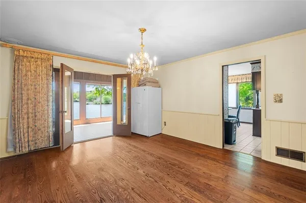 a view of a big room with wooden floor and windows